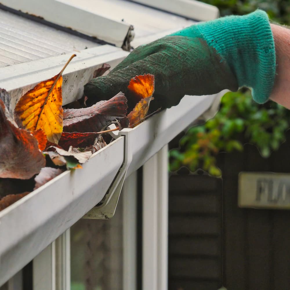 Removing leaves and debris from a clogged residential gutter